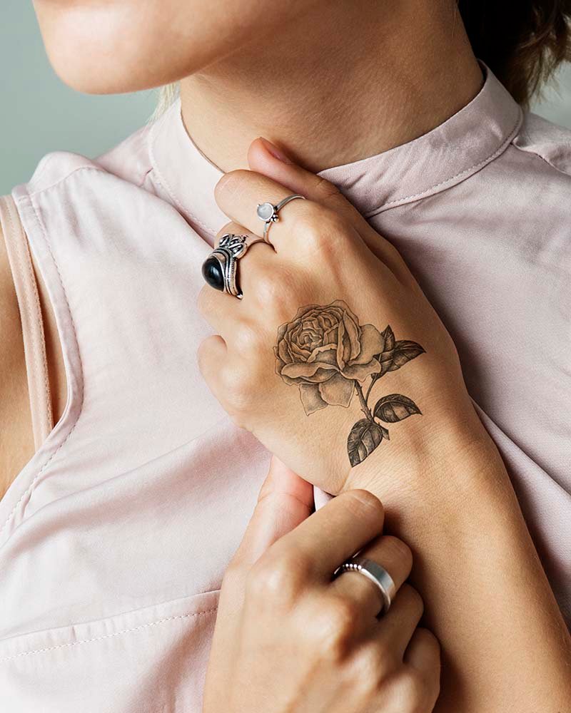 Primer plano de un tatuaje en la mano de una mujer, mostrando detalles artísticos y creatividad en el diseño.